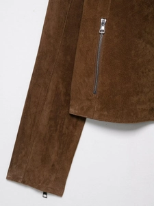 Détail de veste en daim marron foncé montrant la texture épaisse et le zip métallique