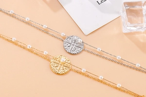 Detail view of double-layer stainless steel bracelet with star pendant and white pearls