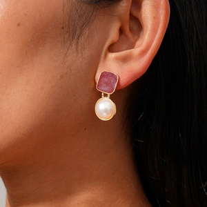 Boucles d'oreilles vintage en résine rouge dorée et perle portées par un mannequin