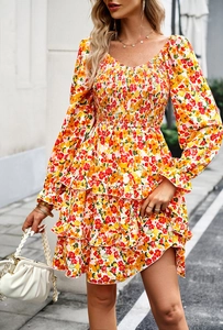 Detail of floral tiered dress with smocked chest and long sleeves in outdoor street view