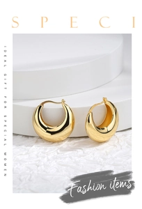Detailed close-up of chunky gold-plated C-shaped earrings with a high-polished finish