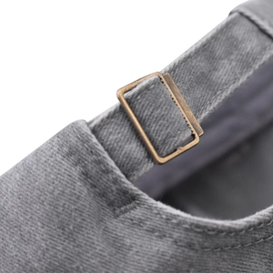 Detailed close-up of gray washed cotton baseball cap with adjustable bronze metal buckle strap