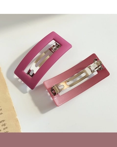 Detail view of pink and magenta rectangle hair clips with durable metal spring fastener