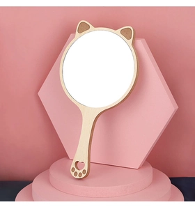 Detail of cat-ear wooden hand mirror with cat-paw cutout handle on pink display stand