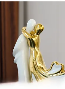 Détail d'une sculpture de couple moderne en céramique avec finition blanche et dorée polie
