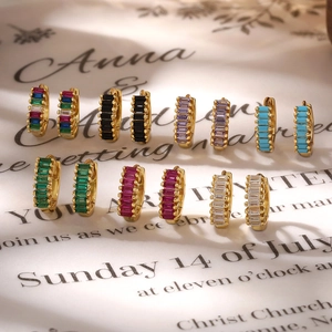 Close-up of gold hoop earrings with emerald, ruby and sapphire baguette zircons