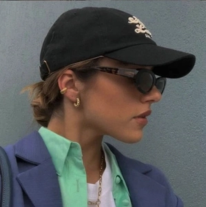 Detail of twisted 18K gold-plated hoop earrings paired with a modern fashion outfit