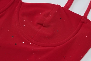 Detailed view of red dress bodice featuring shimmering sequins and delicate mesh texture