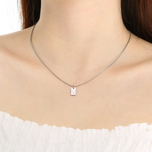 Minimalist silver rectangle pendant necklace with engraved letter A worn on a model