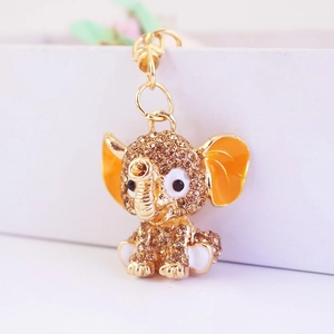 Detailed macro view of the gold elephant charm with brown rhinestones and orange enamel ears