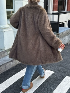 Manteau élégant en fausse fourrure marron à manches longues dans une scène de rue urbaine