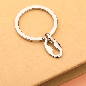 Macro shot of silver metal keychain with oval pendant and keyhole cutout on paper