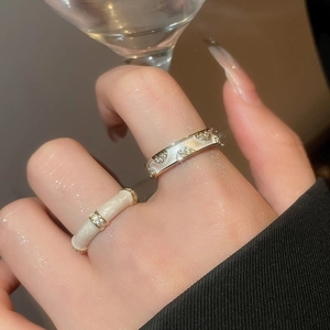 Detail of 18k gold plated double-layer rings with zircon stones and enamel on finger