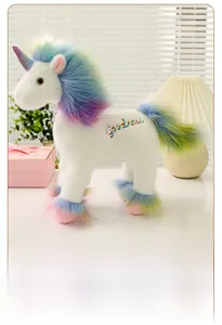 Nahaufnahme weißes Einhorn-Stofftier mit Regenbogenfell und bunter Stickerei