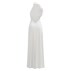 Détail d'une robe dos nu en satin blanc avec une fleur à volants texturée sur l'épaule