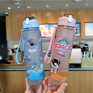 Close-up of pink and blue astronaut water bottles with straw lids and cartoon stickers