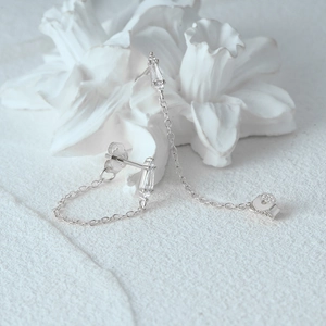 Detail of S925 sterling silver earring featuring sparkling zircon stones and long chain