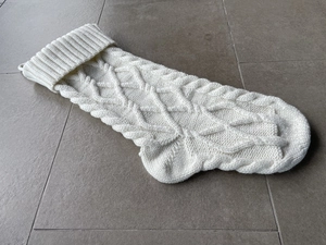 Detail of cable knit Christmas stocking in cream white with classic textured pattern