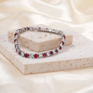 Micro-pave bracelet featuring alternating ruby and white gemstones on a silver base