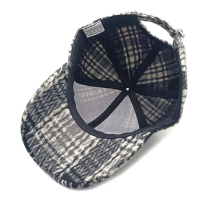 Detail view of plaid baseball cap interior with mesh lining and polyester wash label