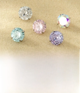 Detailed view of 6mm titanium alloy zircon studs in five vibrant colors with claw setting