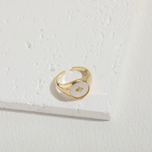 Macro detail of gold vintage ring with white shell inlay and star zircon accent