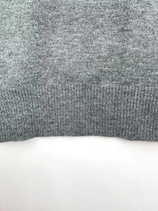 Close-up detail of grey ribbed knit hem showing high-quality texture and stitching