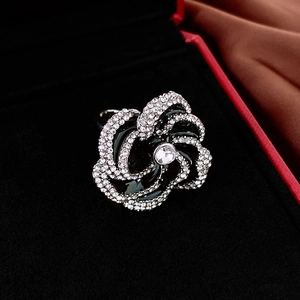 Detail of vintage camellia ring with black enamel and micro-set diamonds in a gift box