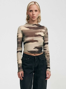 Dettaglio dei bordi a volant su scollatura e polsini di questo top in mesh animalier