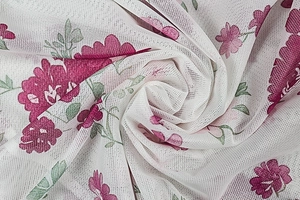 Detail of floral printed mesh fabric featuring pink blooms on white semi-transparent gauze