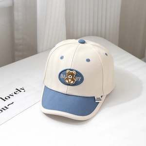Detail of baby baseball cap featuring a cute bear patch and blue contrast brim edge
