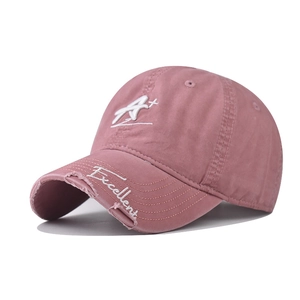 Détail de la casquette rose en coton lavé avec broderie A+ et bord de visière usé