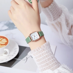 Elegant rose gold square watch with avocado green leather strap on female wrist
