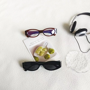 Vintage cat eye sunglasses and oval frames on white fabric with casual props lifestyle