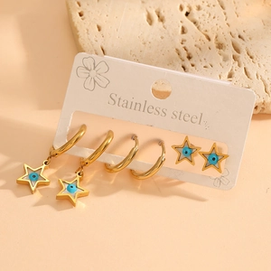Detailed set of gold stainless steel star earrings with blue evil eye charms on beige card