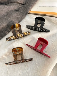 Set of four handmade acrylic hair claws in assorted tortoise shell and amber patterns