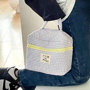 Dettaglio borsa trapuntata a quadri lavanda con cerniera gialla e comodo manico a mano