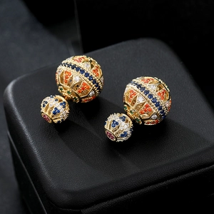 Macro view of double-sphere earrings featuring colorful zircon micro-paving in gold finish
