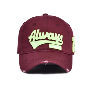 Close-up of distressed brim and neon green embroidery on vintage burgundy baseball cap