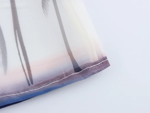 Dettaglio dell'orlo della camicia in organza con sagome di palme e stampa sfumata