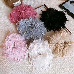 Chouchous chic en plumes duveteuses en six couleurs sur fond de polaire blanche