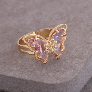 Macro detail of 18K gold butterfly ring with pink crystals and micro-pave diamonds