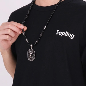 Detail of vintage stainless steel lion head pendant with black beaded chain necklace