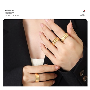Detail of 18K gold-plated chunky ribbed croissant rings on model hand in minimalist style