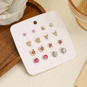 Lot de 8 paires de boucles d'oreilles dorées avec cœurs, étoiles et pierres roses sur carte