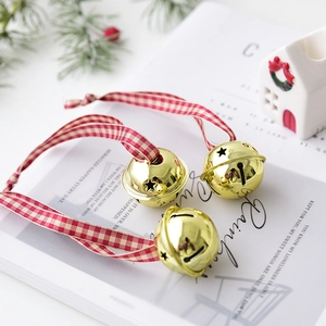 Three golden Christmas bell ornaments with star cutouts and festive red plaid ribbons