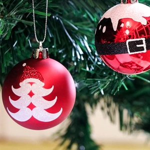 Détails de boules de Noël rouges avec motifs de Père Noël et flocons de neige scintillants