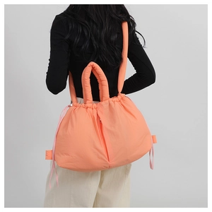 Detailed view of orange puffer nylon tote bag with drawstring closure and shoulder strap