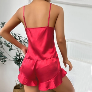 Women's red two-piece silk-like pajama set featuring camisole top and ruffled shorts