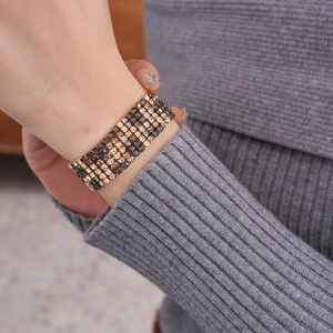 Detailed macro view of wide gold and black rhinestone leopard pattern bracelet on wrist